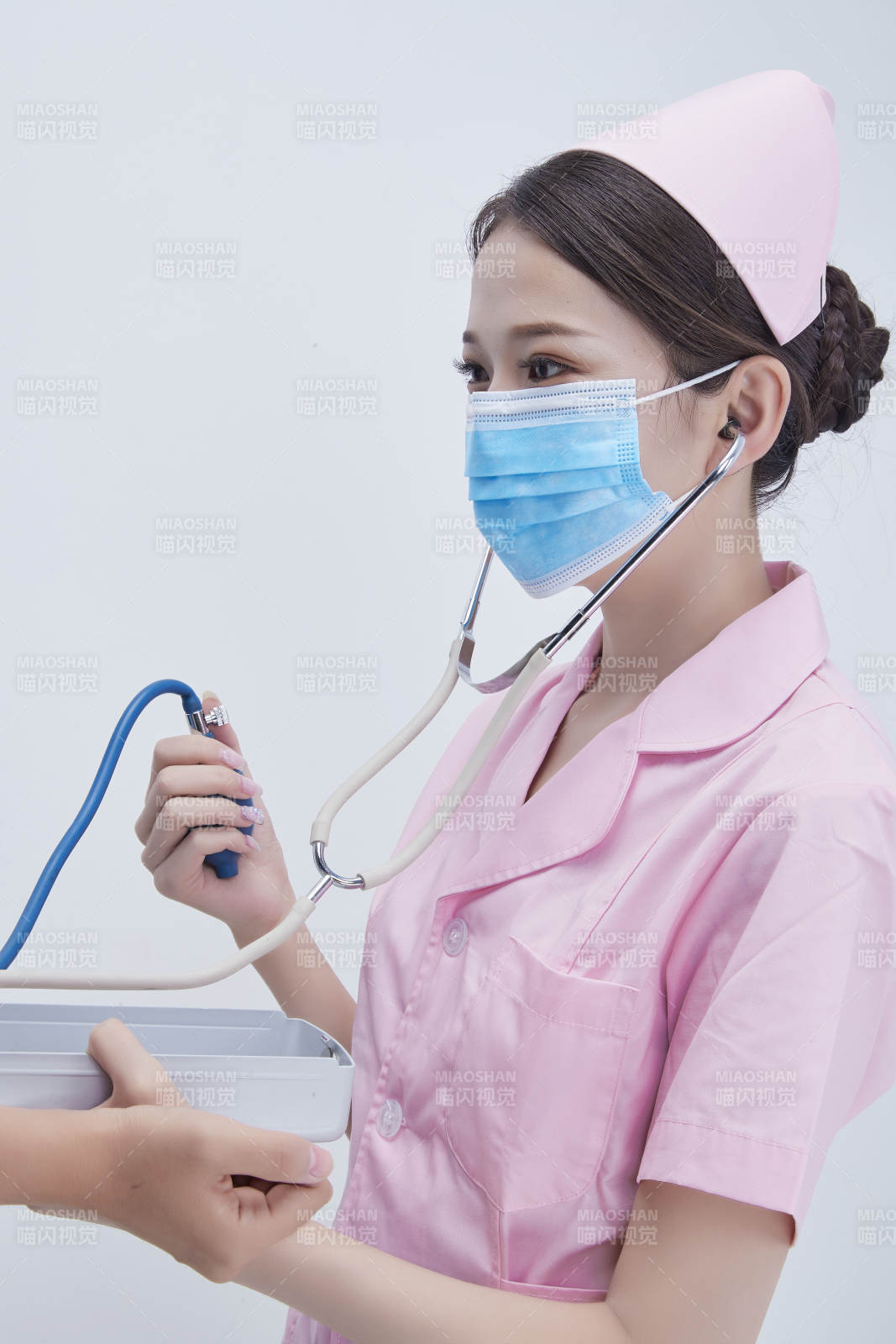 手拿血壓測量儀為患者診治量血壓的女性護士