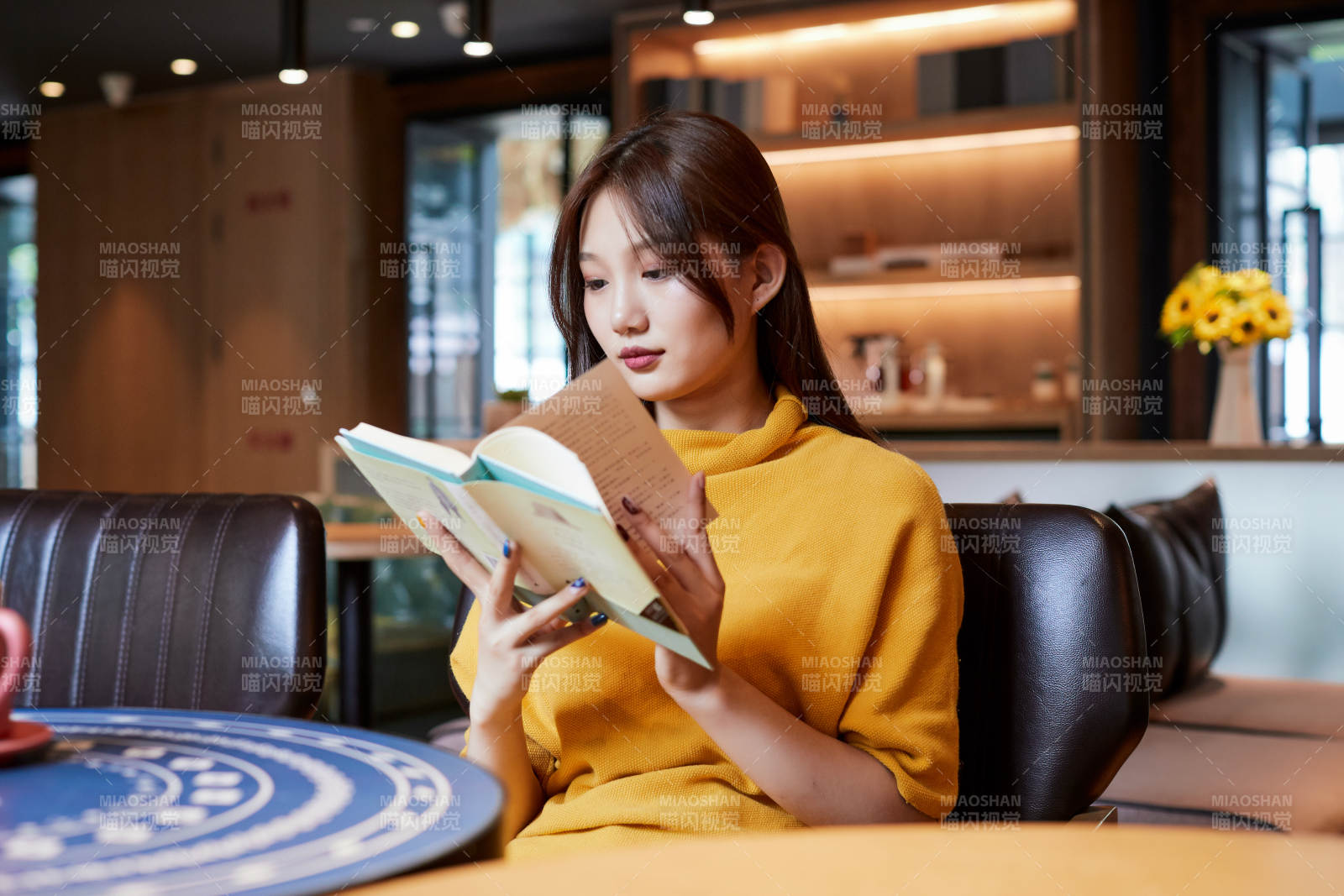 在圖書咖啡館閱讀書籍的少女