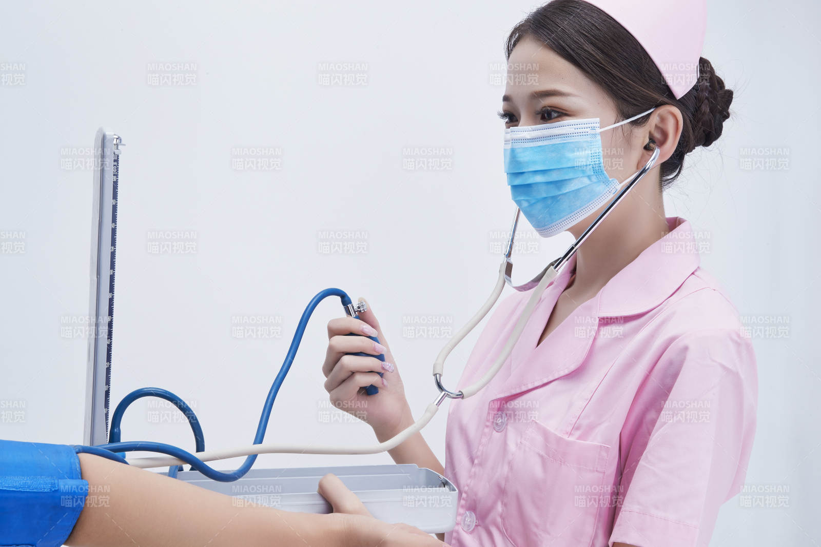 手拿血壓測量儀為患者診治量血壓的女性護士