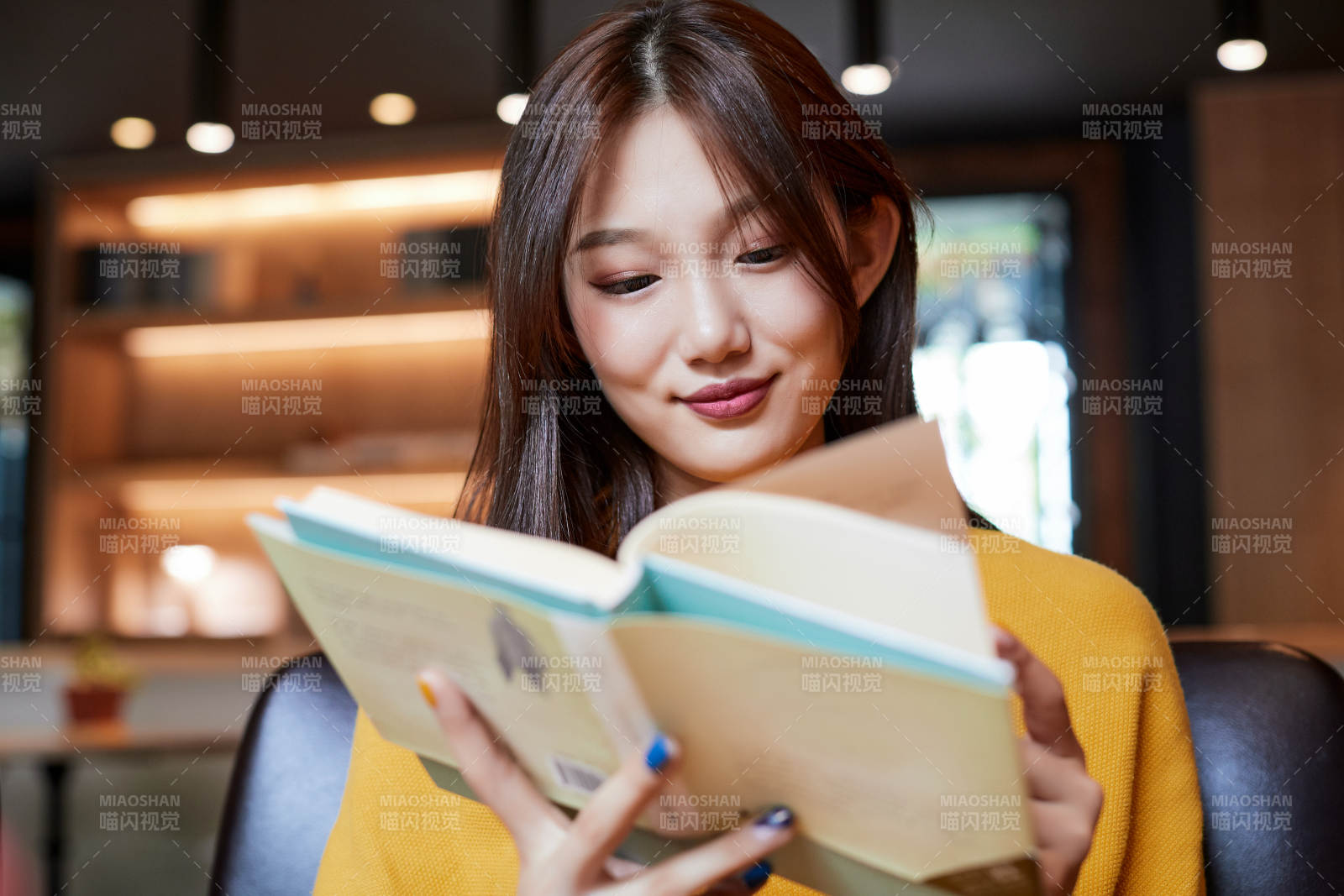 在圖書咖啡館閱讀書籍的少女