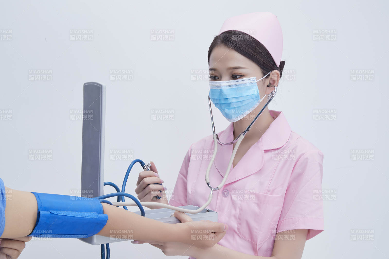 手拿血壓測量儀為患者診治量血壓的女性護士