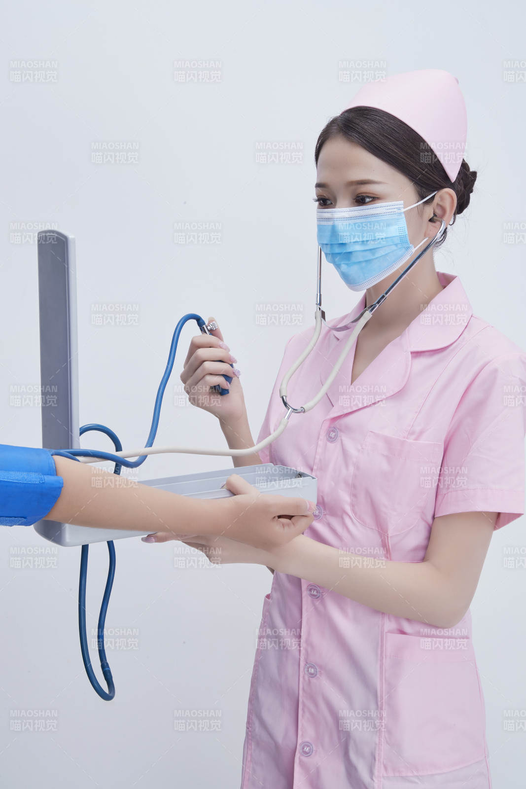 手拿血壓測量儀為患者診治量血壓的女性護士