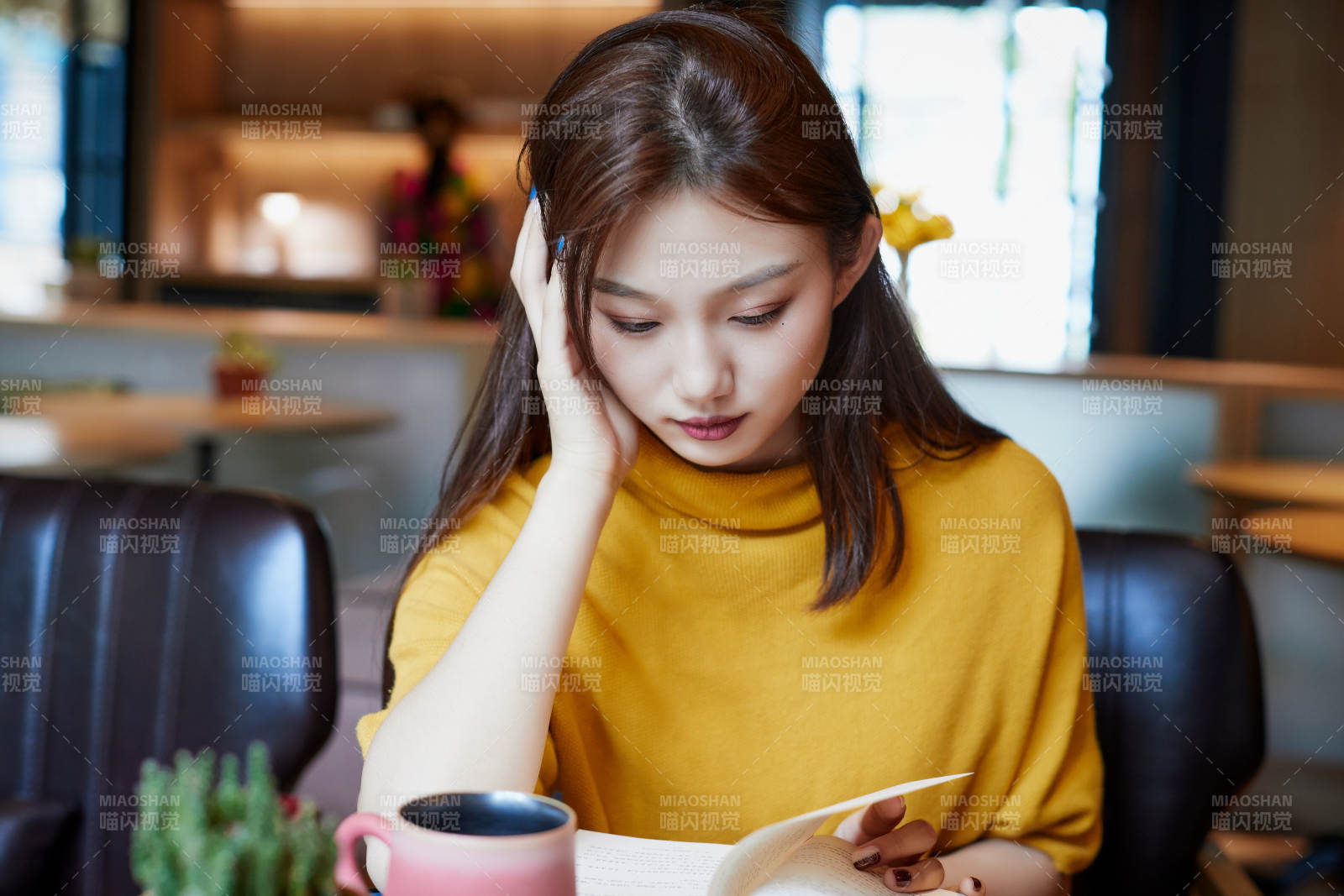 在圖書咖啡館閱讀書籍的少女