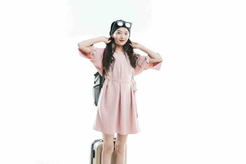 白色背景下准备出发旅行的美丽东方女大学生