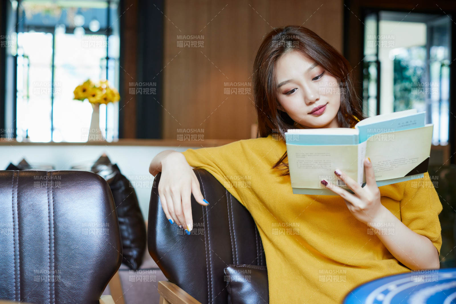 在图书咖啡馆阅读书籍的少女