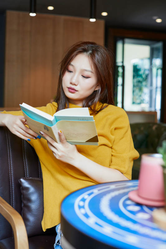 在图书咖啡馆阅读书籍的少女