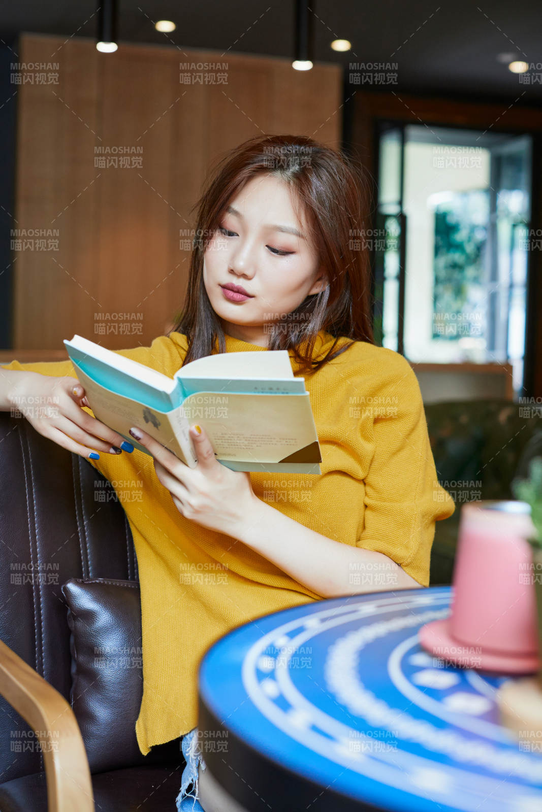 在图书咖啡馆阅读书籍的少女