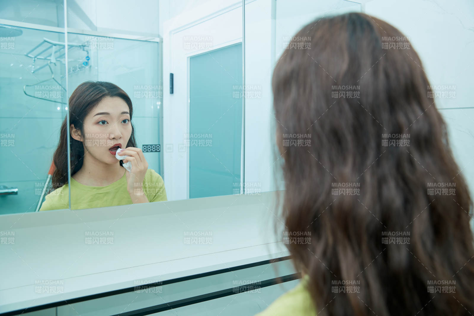 在卫生间对着镜子整理妆容的亚洲少女