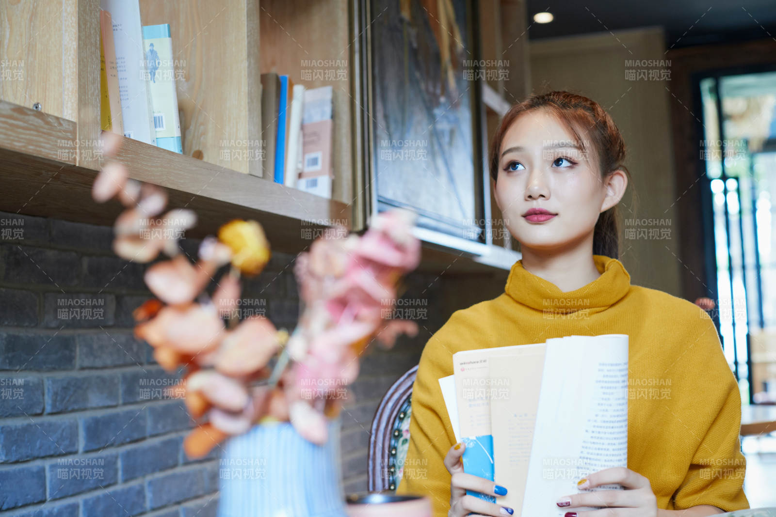 在图书咖啡馆阅读书籍的少女