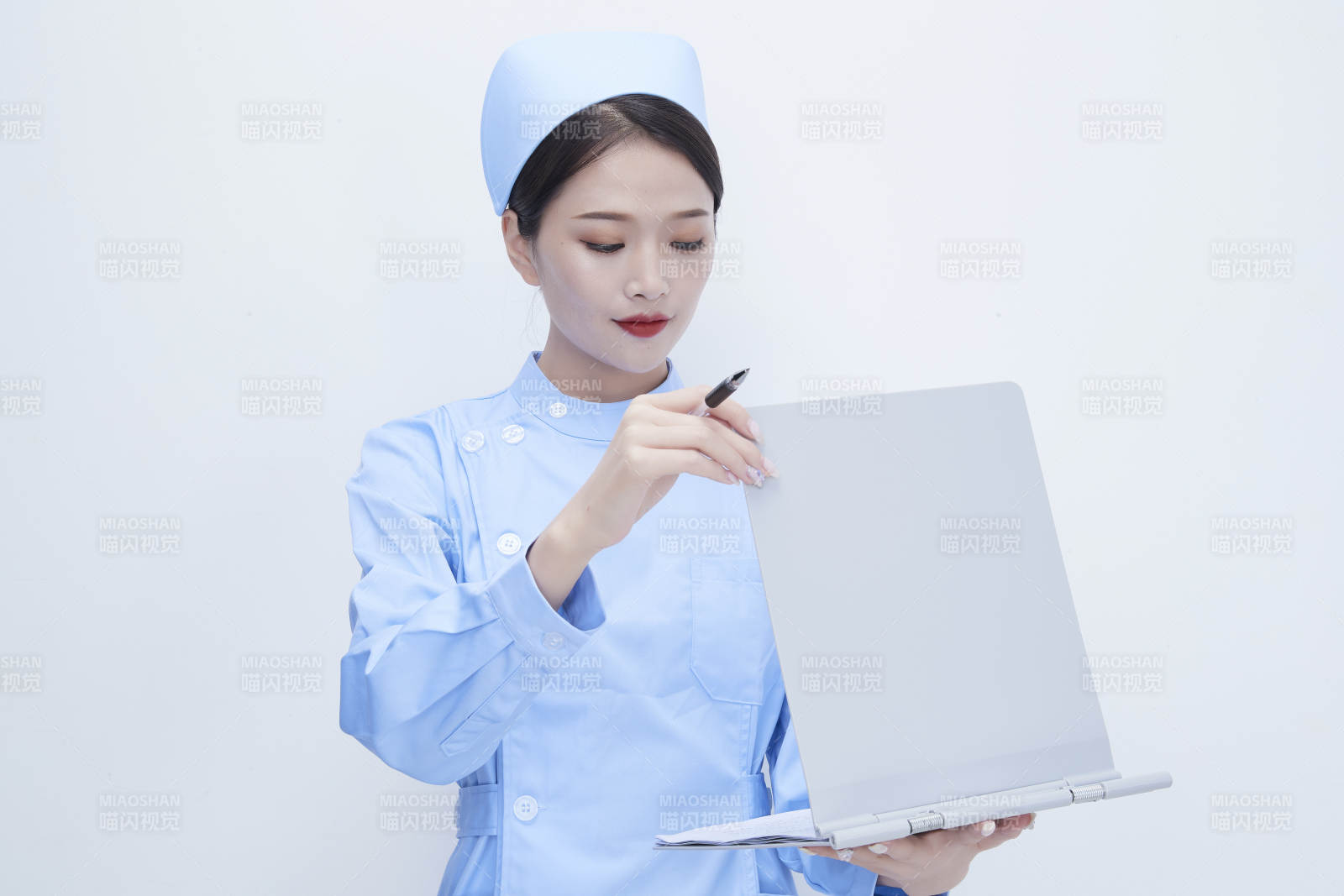 白背景里穿蓝色护士服手持病历夹的美女护士