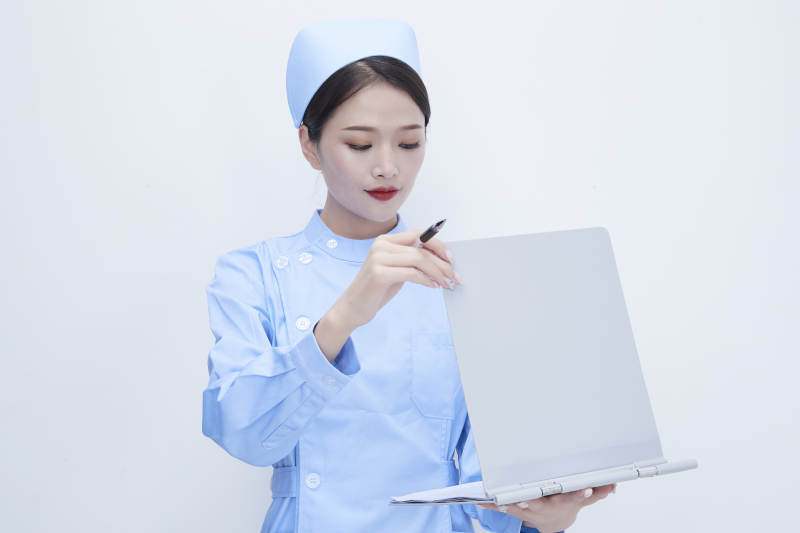 白背景里穿蓝色护士服手持病历夹的美女护士