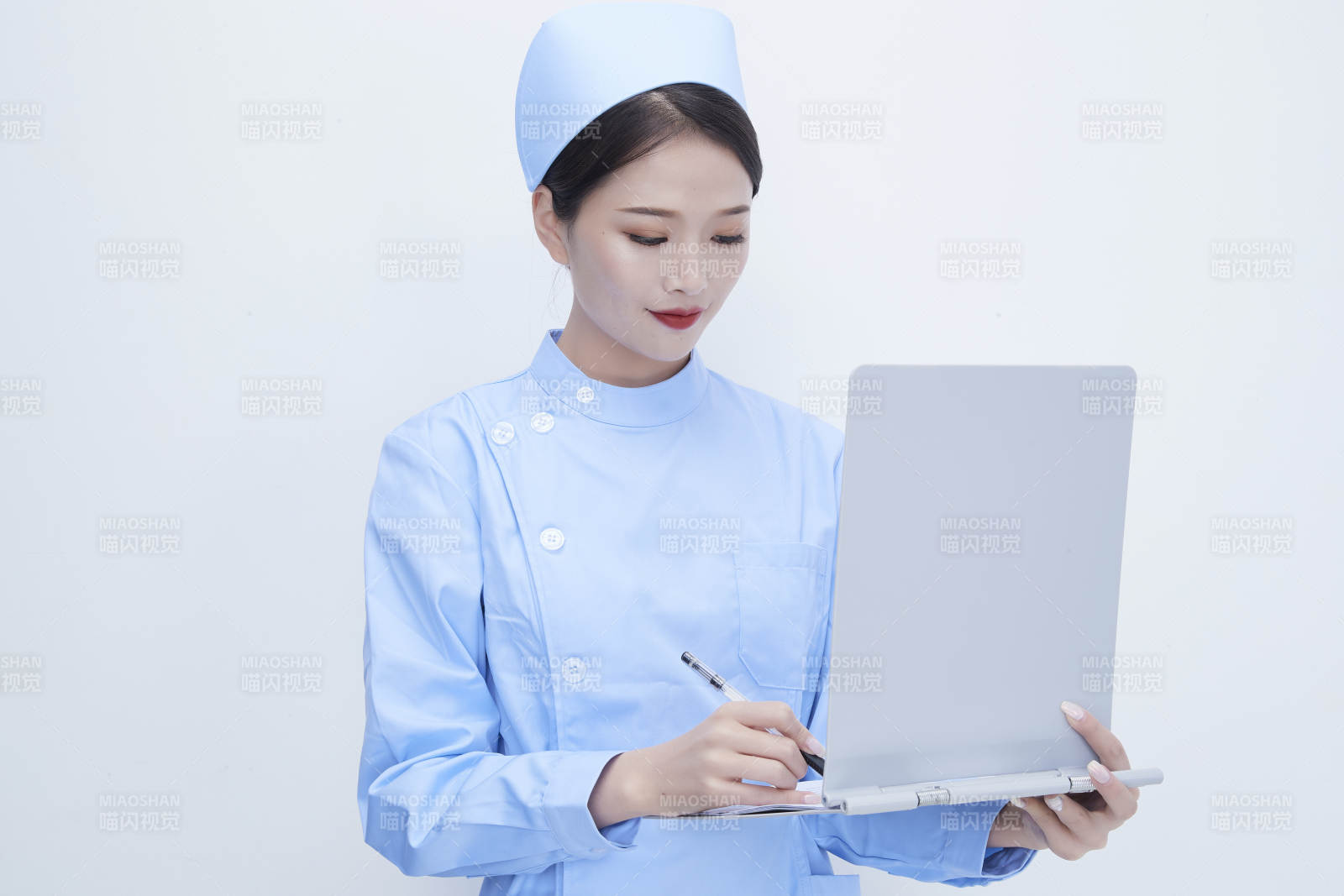 白背景里穿蓝色护士服手持病历夹的美女护士