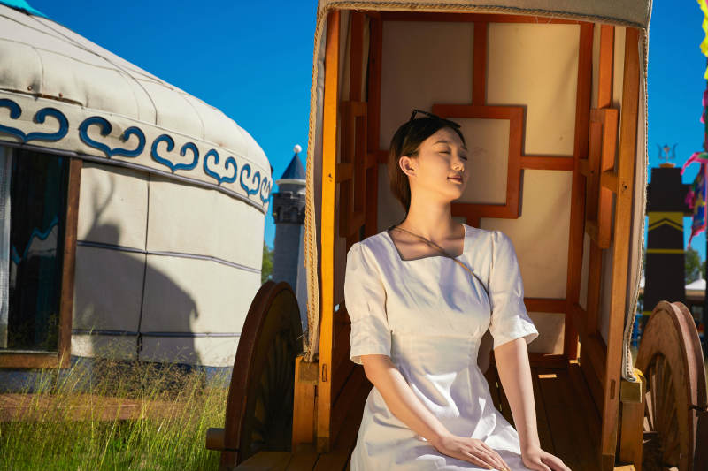 草原湿地公园游玩拍照的亚洲少女