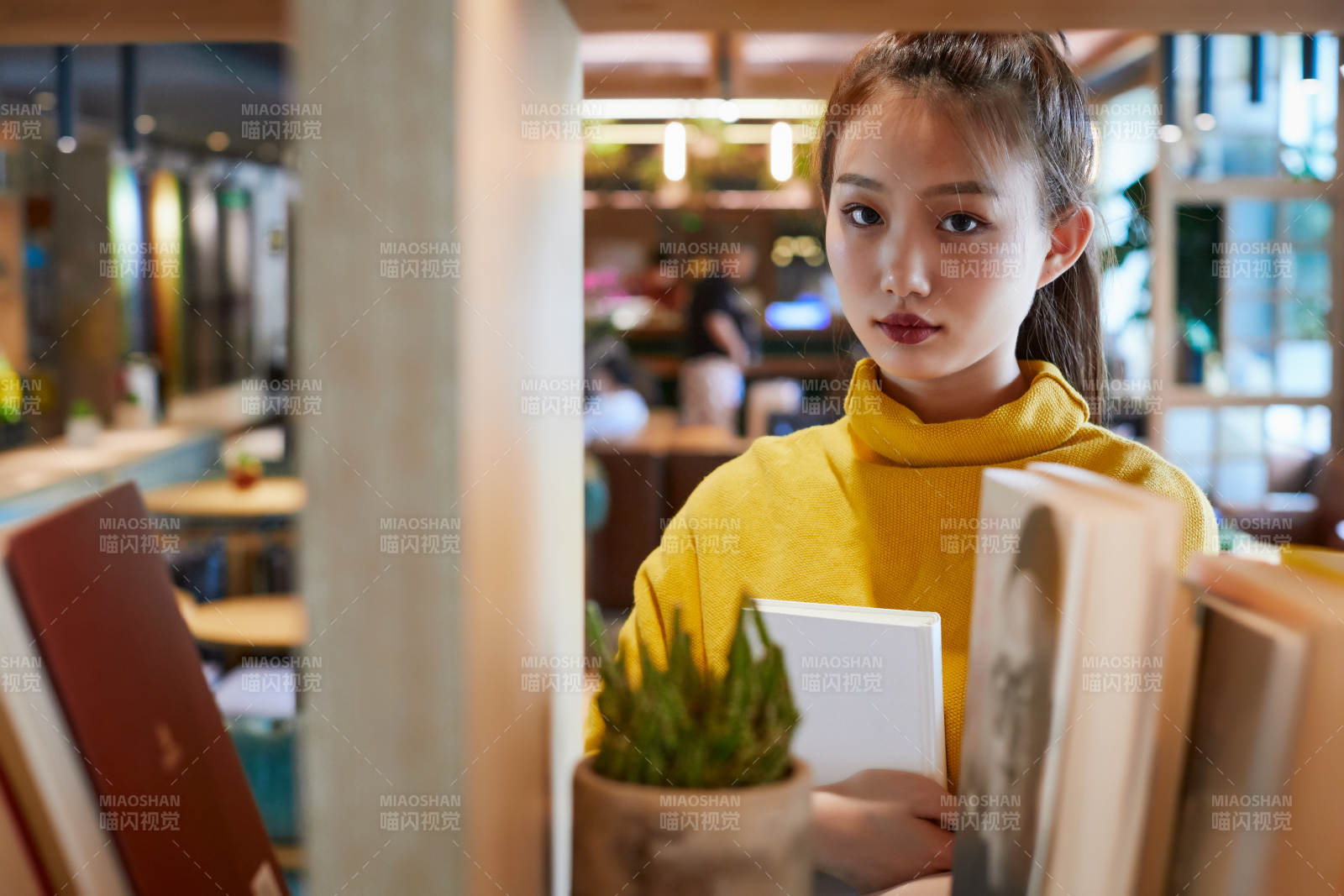 在图书咖啡馆阅读书籍的少女