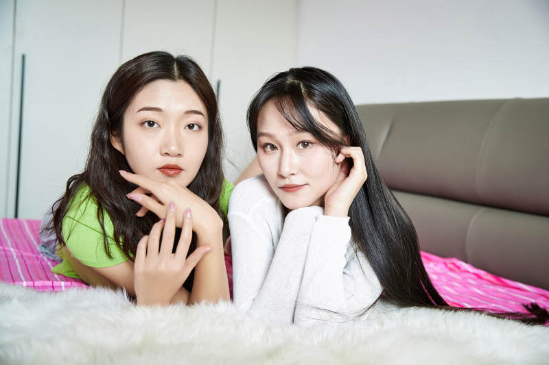 坐在床上玩耍的年轻亚洲美女闺蜜