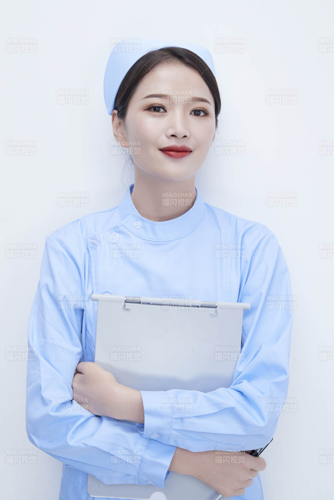 白背景里穿藍色護士服手持病歷夾的美女護士