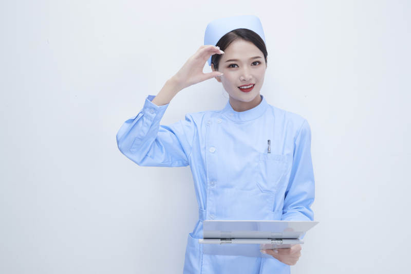 白背景里穿蓝色护士服手持病历夹的美女护士