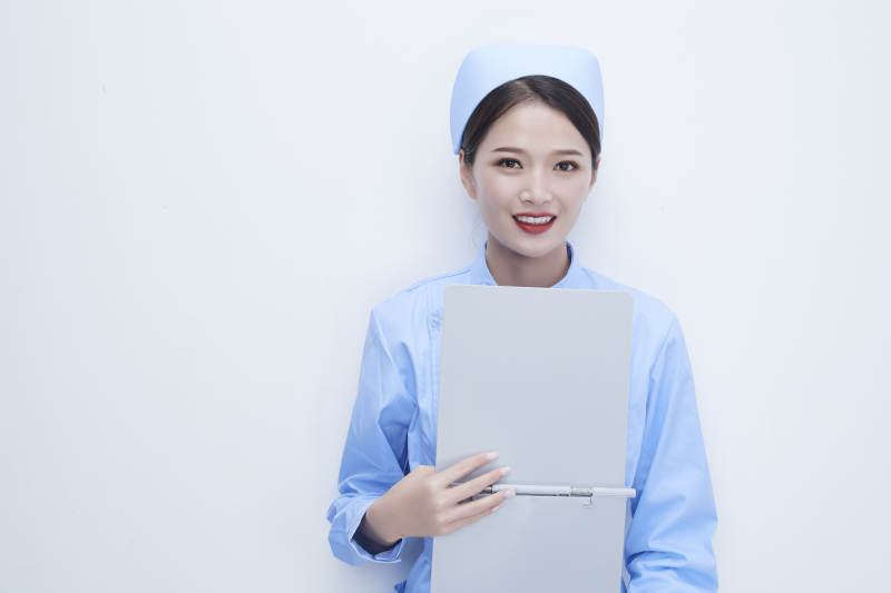 白背景里穿蓝色护士服手持病历夹的美女护士