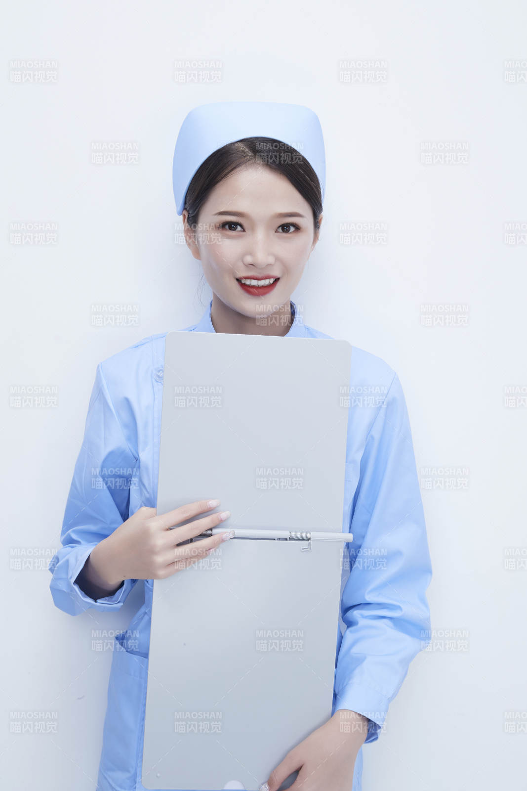 白背景里穿藍色護士服手持病歷夾的美女護士