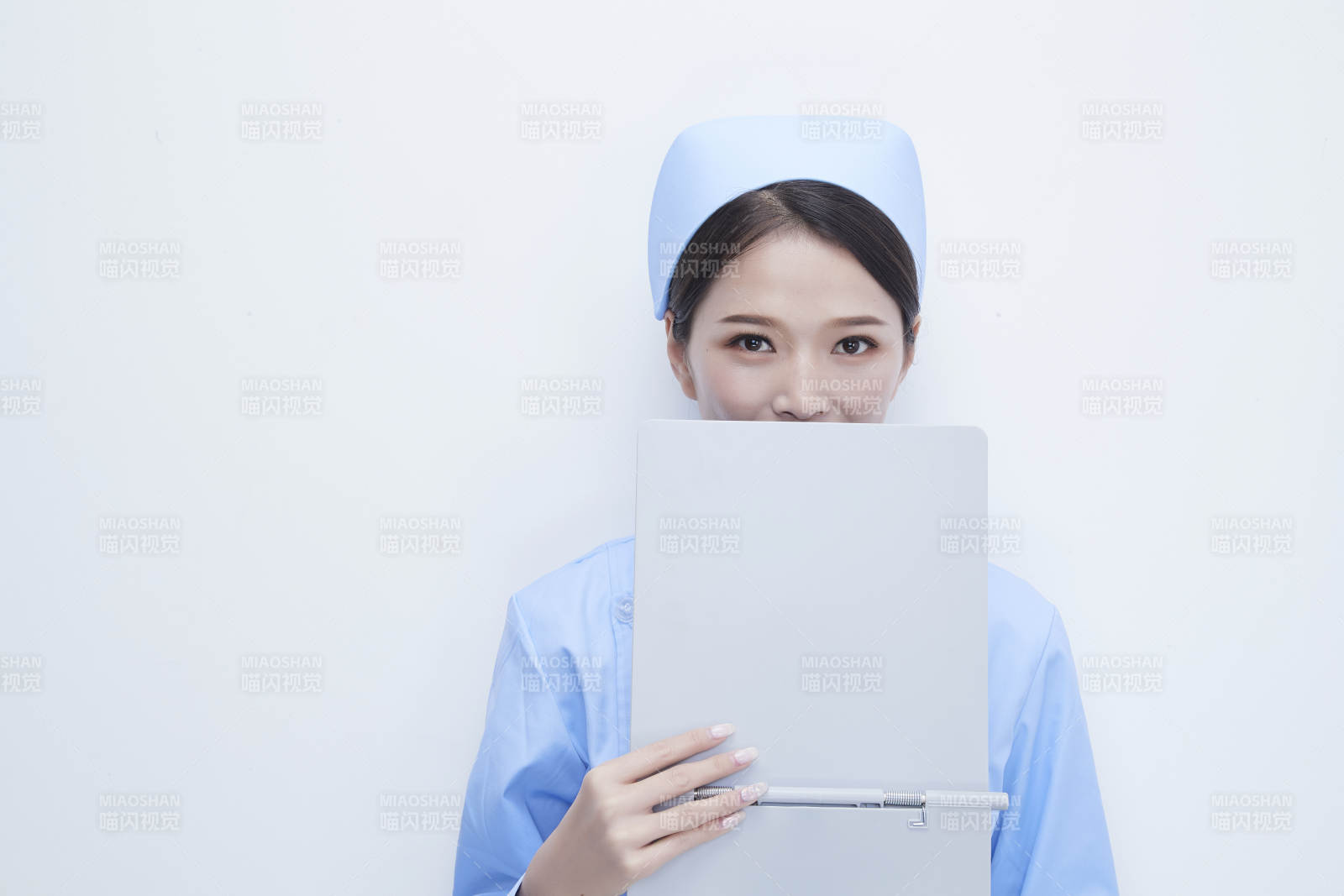 白背景里穿蓝色护士服手持病历夹的美女护士