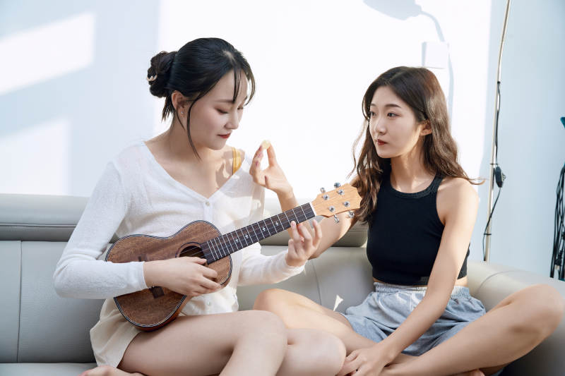 坐在沙发弹琴唱歌俩位美女闺蜜