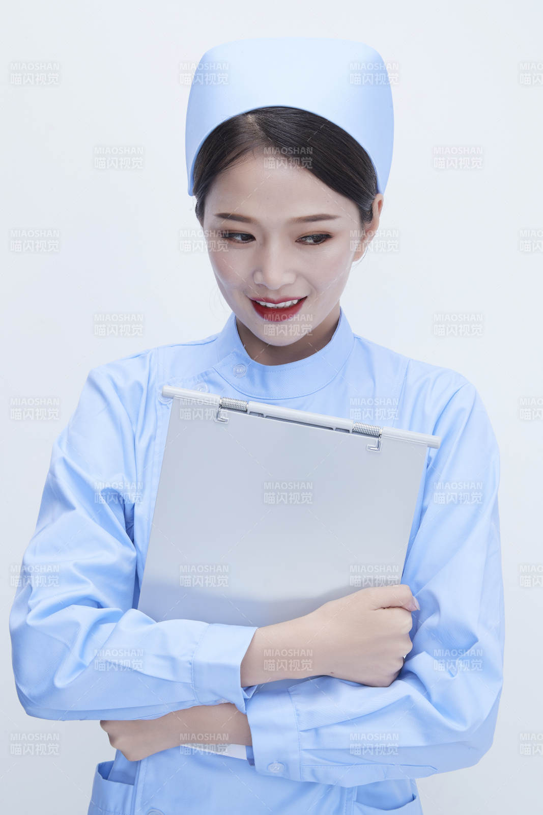 白背景里穿藍色護士服手持病歷夾的美女護士