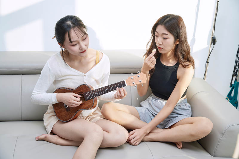 坐在沙发弹琴唱歌俩位美女闺蜜