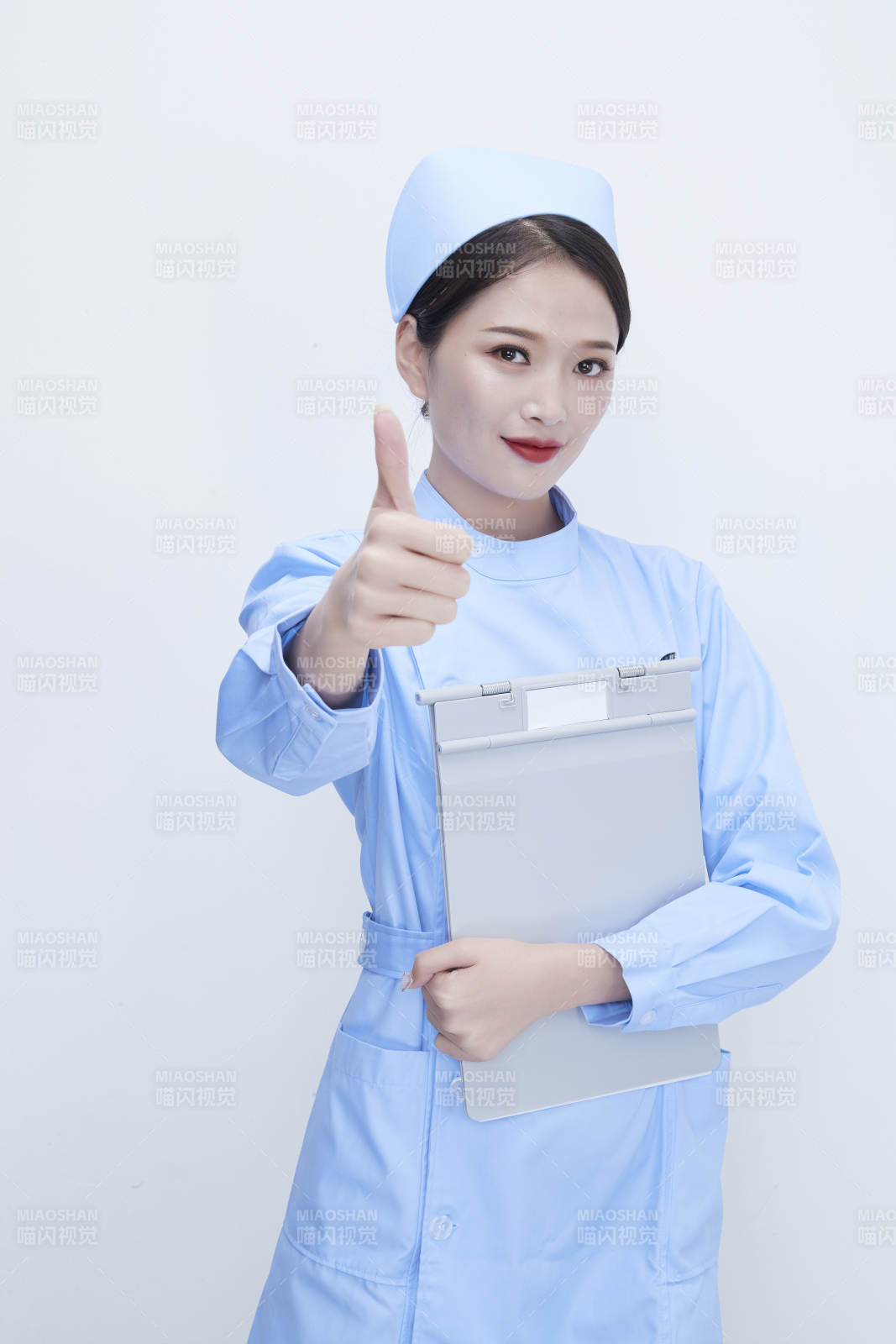 白背景里穿藍(lán)色護(hù)士服手持病歷夾的美女護(hù)士