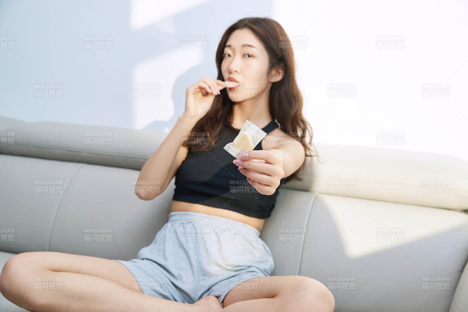 在家在沙发上享受美食的亚洲少女