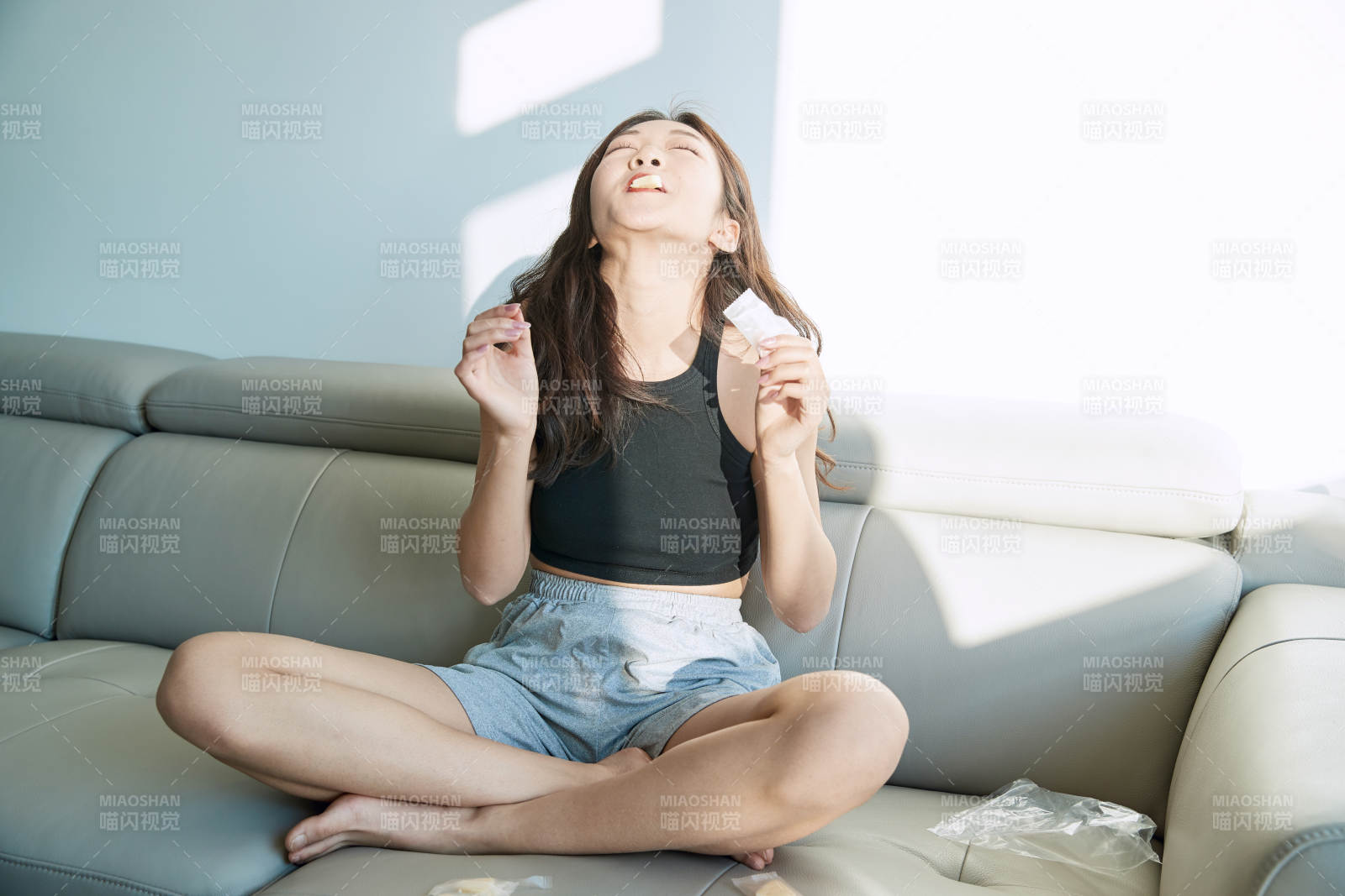 在家在沙發(fā)上享受美食的亞洲少女