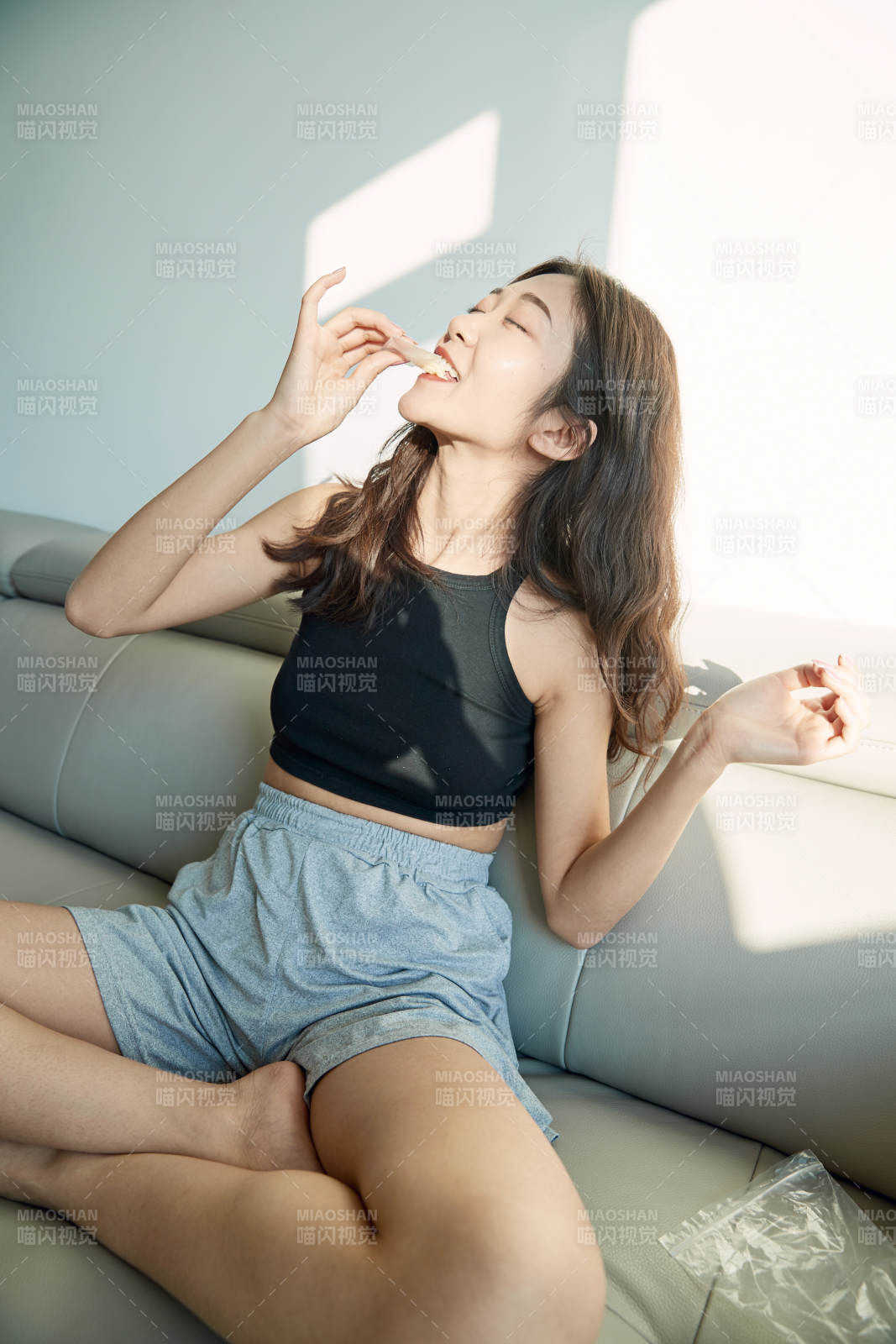 在家在沙发上享受美食的亚洲少女