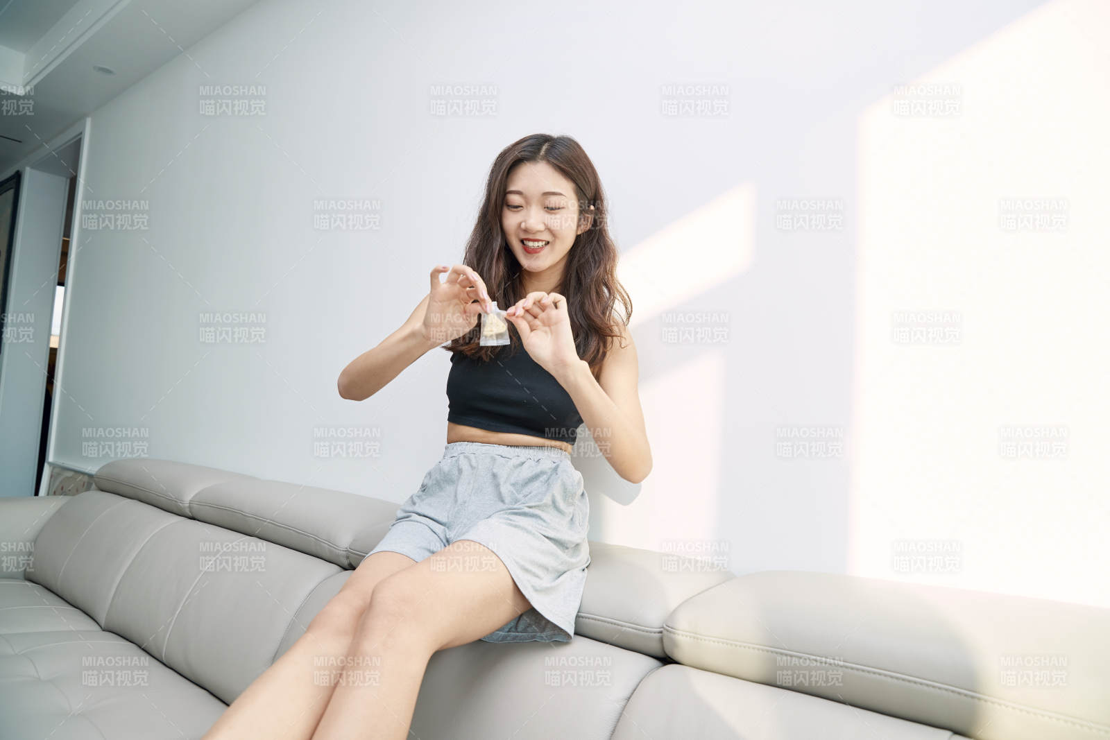 在家在沙發(fā)上享受美食的亞洲少女