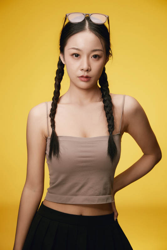 黄色背景下的活泼可爱女大学生