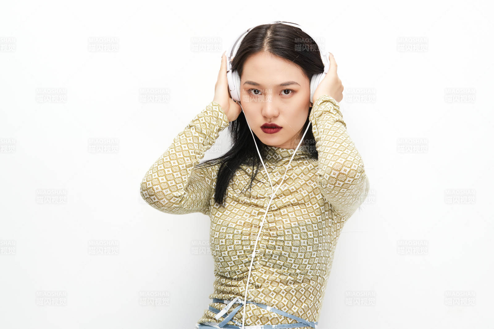 头戴耳机手持电话听音乐的少女