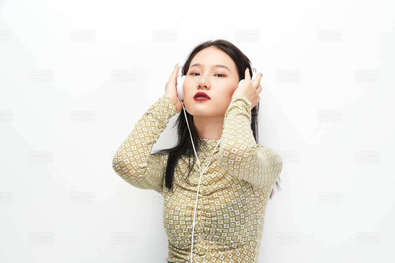 頭戴耳機手持電話聽音樂的少女