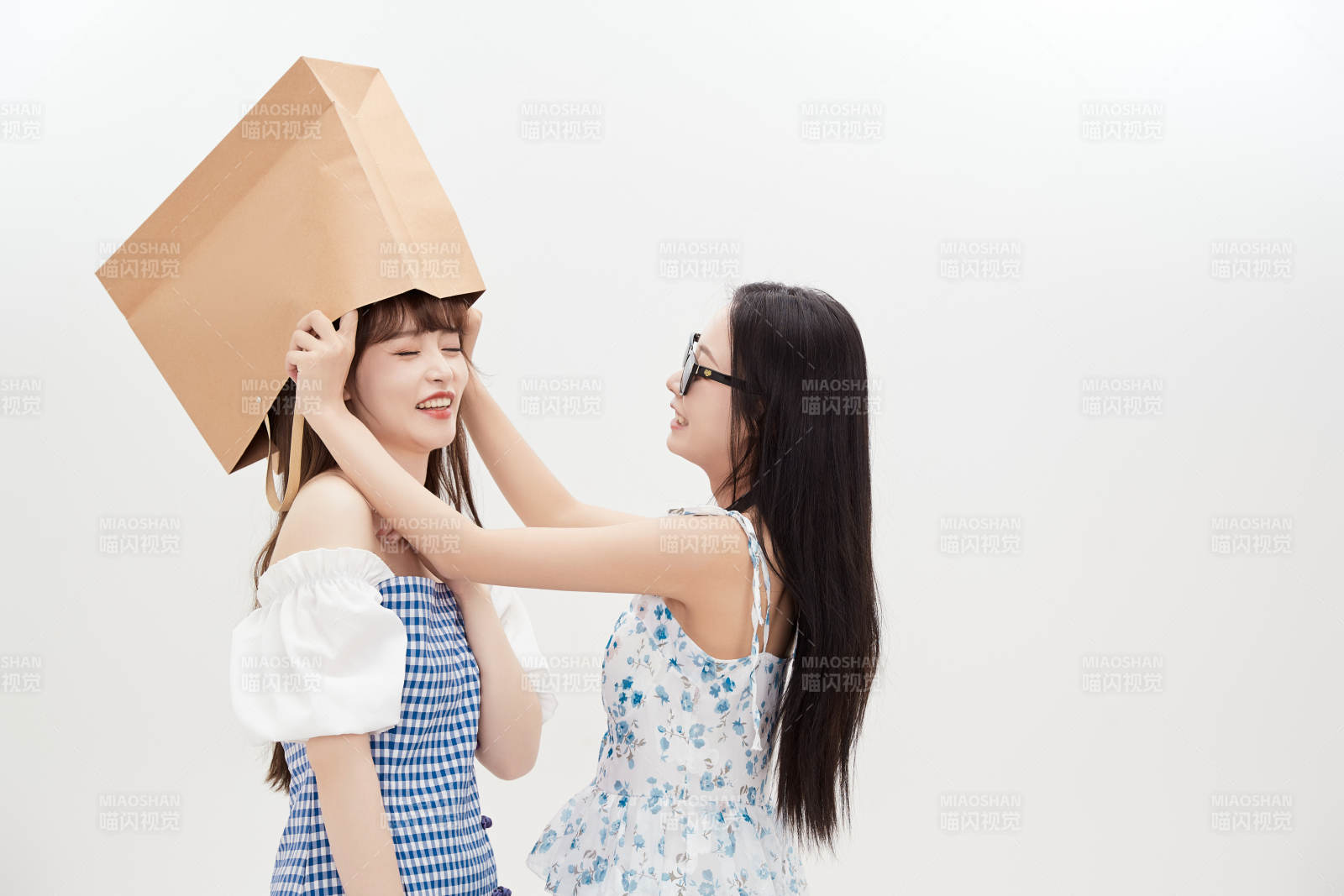 白色背景下手提购物袋时尚美丽的美女闺蜜