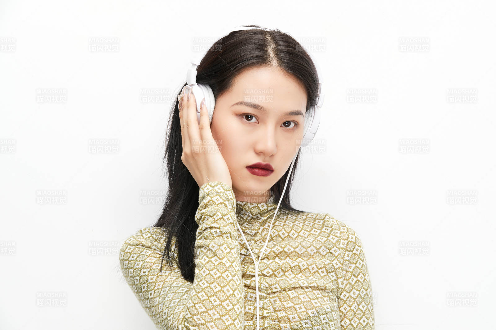 头戴耳机手持电话听音乐的少女