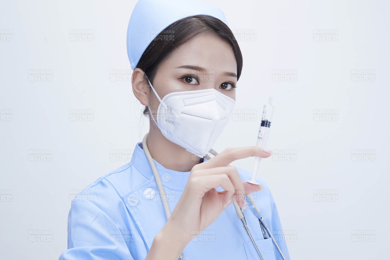 穿护士服戴听诊器口罩和手执针筒的美女护士