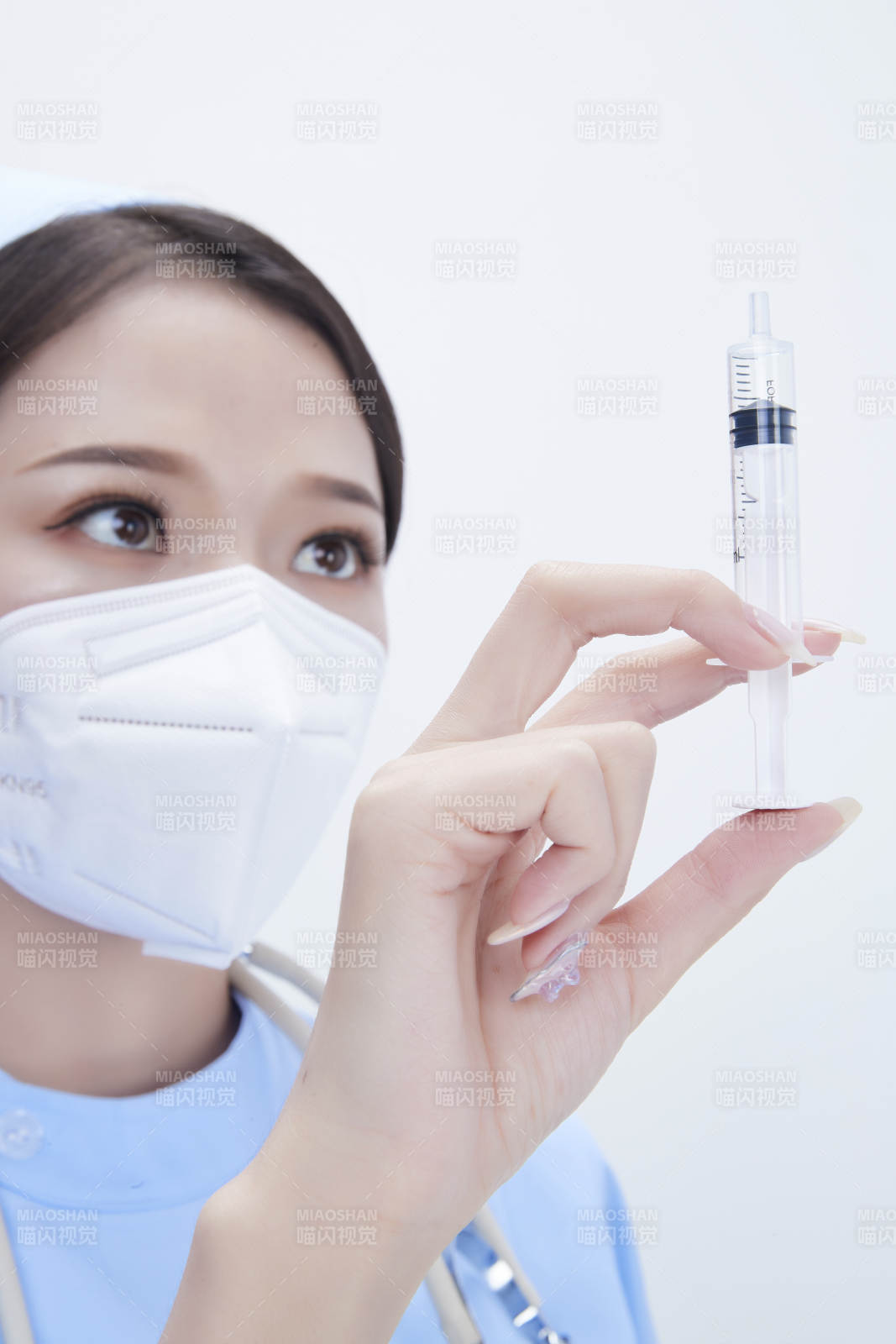 穿護士服戴聽診器口罩和手執(zhí)針筒的美女護士