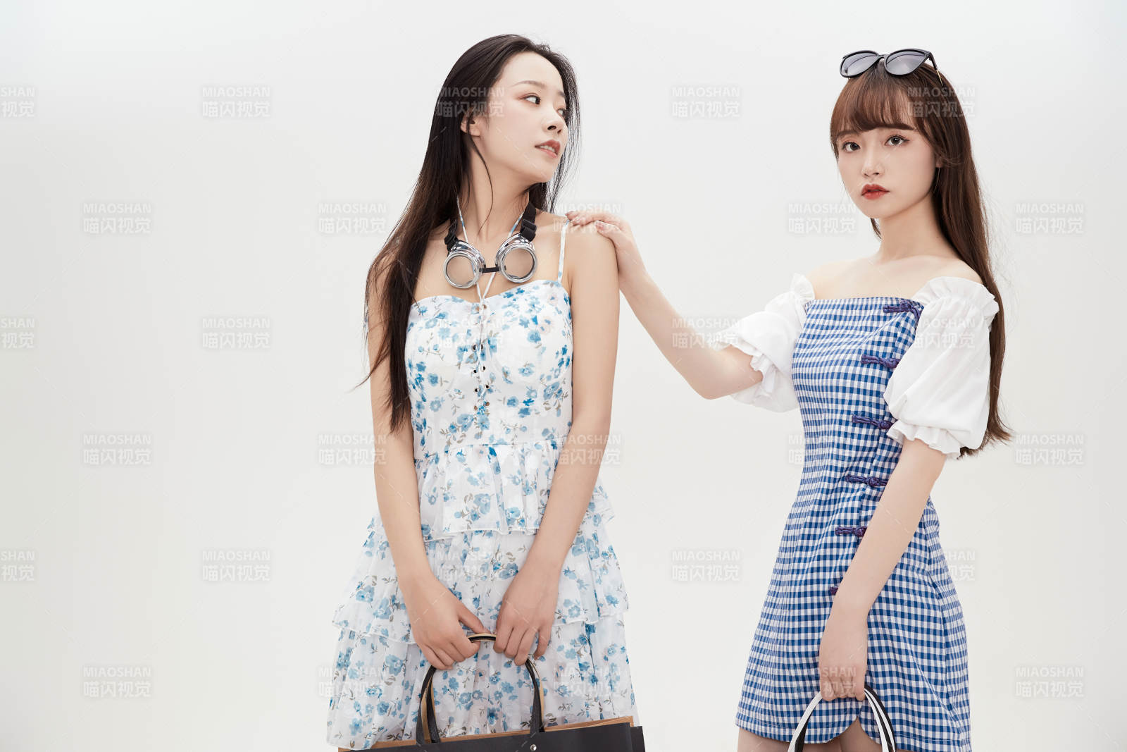 白色背景下手提购物袋时尚美丽的美女闺蜜