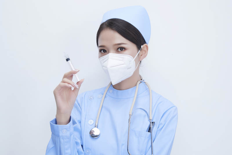 穿护士服戴听诊器口罩和手执针筒的美女护士