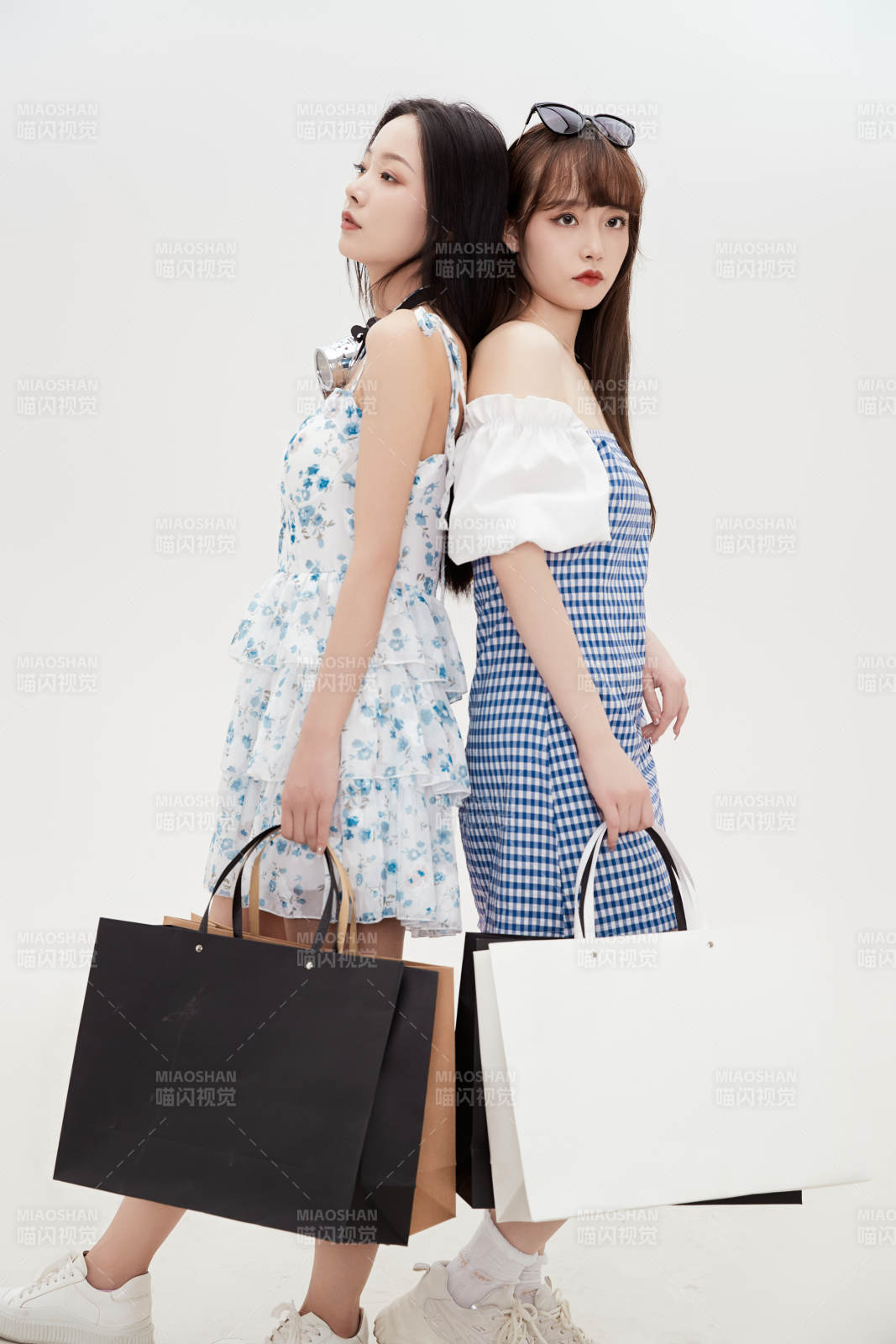 白色背景下手提购物袋时尚美丽的美女闺蜜