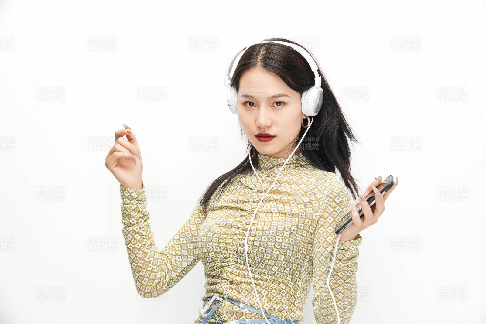 頭戴耳機(jī)手持電話聽音樂的少女