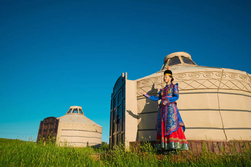 夕阳下草原蒙古大帐前穿蒙族服饰的美女