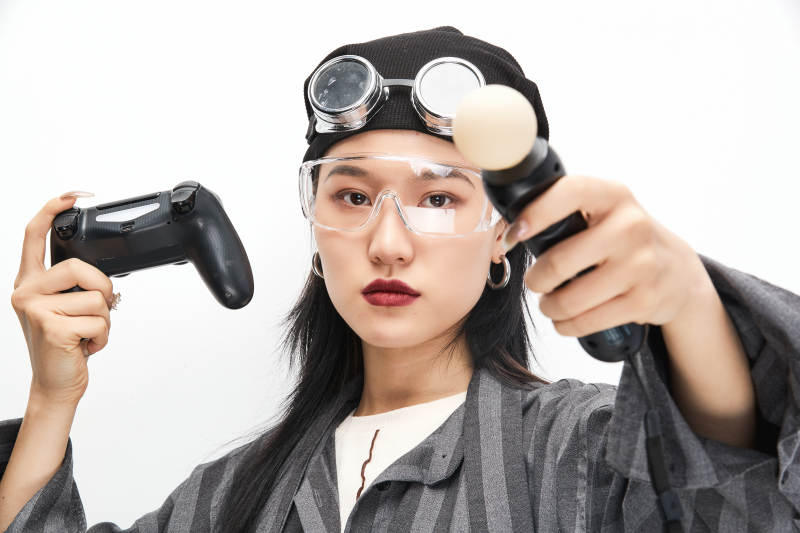 手持电子游戏操控器的亚洲少女