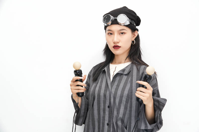 手持电子游戏操控器的亚洲少女