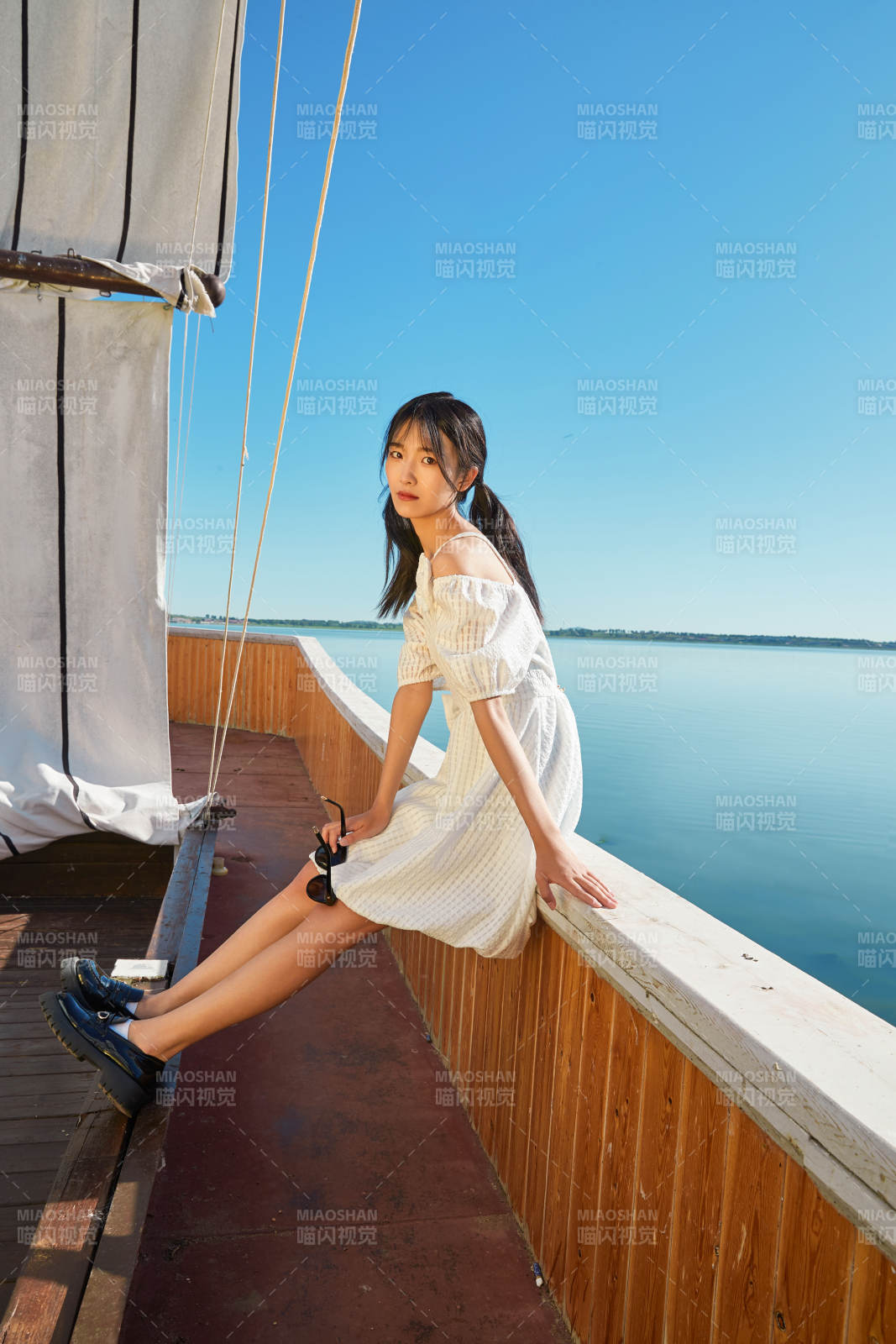 在湖畔木制帆船上的亚洲美女