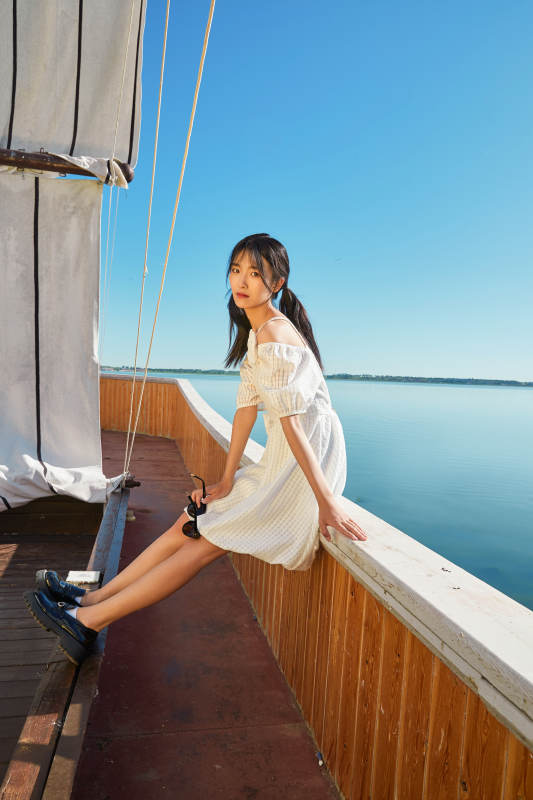 在湖畔木制帆船上的亚洲美女