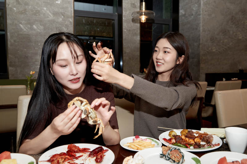 在酒店自助餐厅大吃特吃的亚洲可爱闺蜜少女