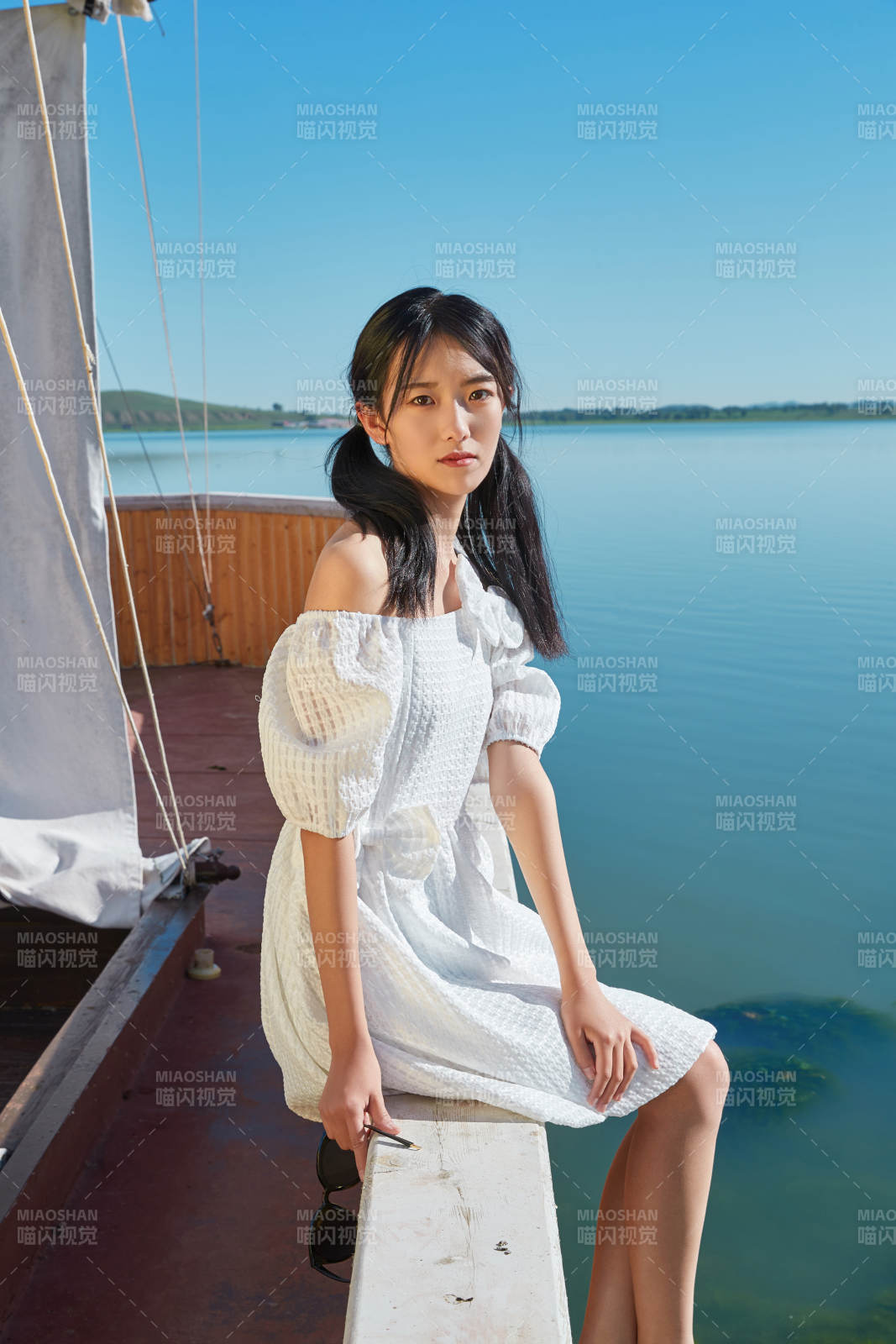 在湖畔木制帆船上的亚洲美女